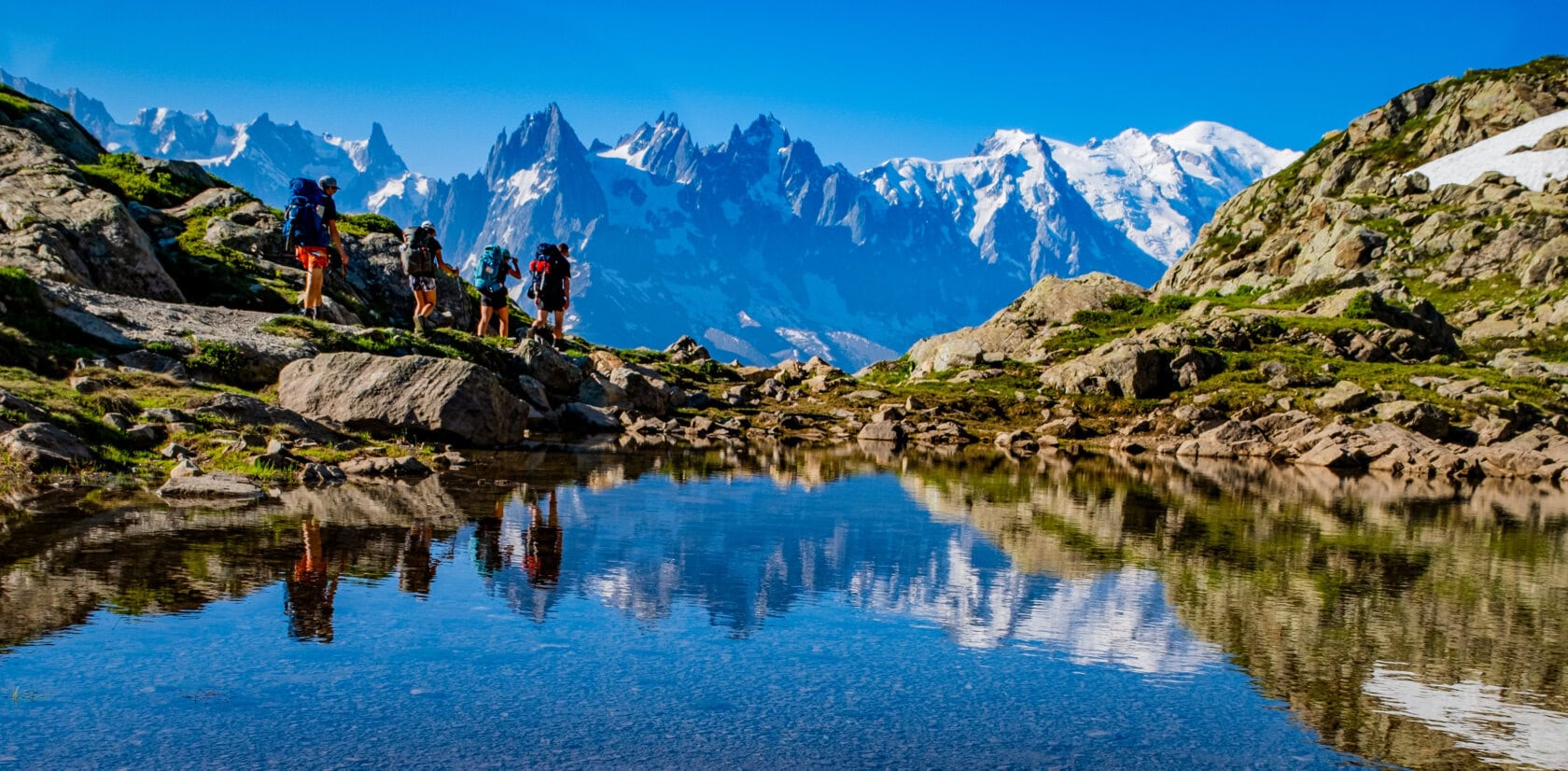 Snowy peaks and hikers on an Alpine trek